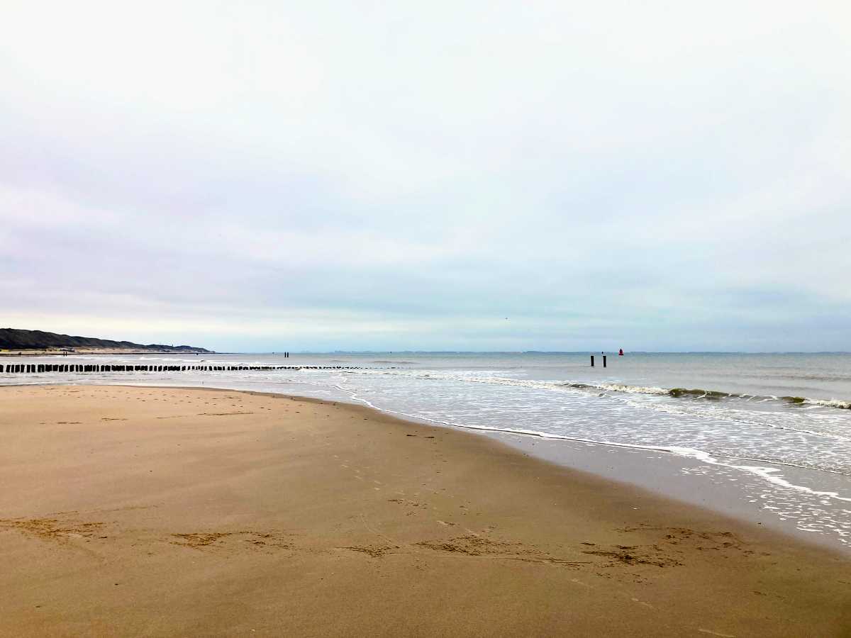 An empty North Sea beach at low tide, the horizon open in every direction.